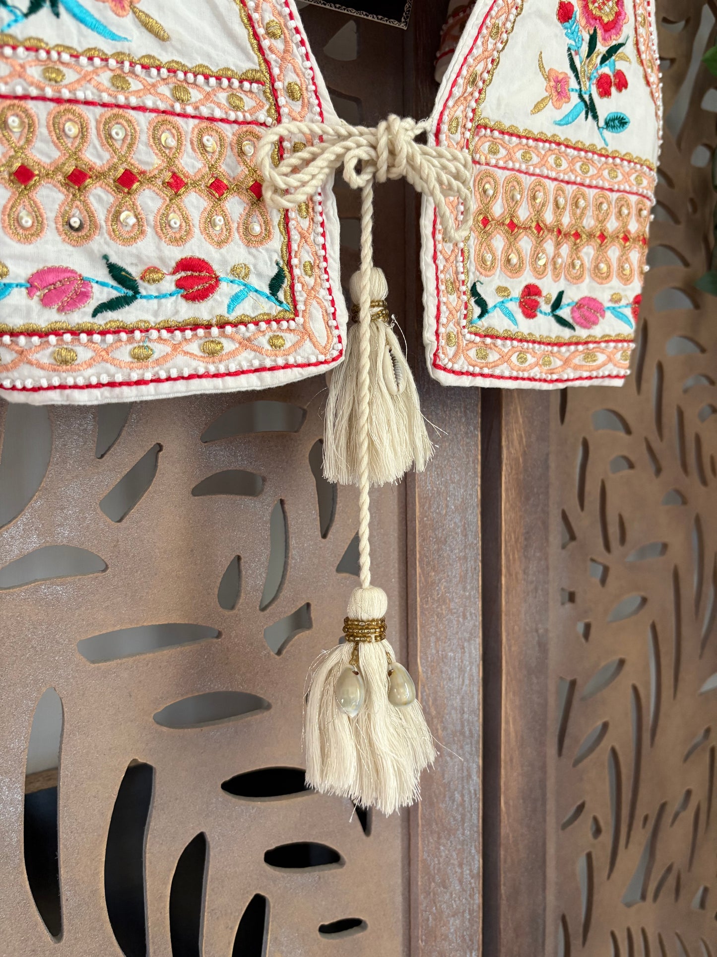 Gilet corto in cotone boho chic floreale ricamato con applicazioni di perline e chiusura con nappe