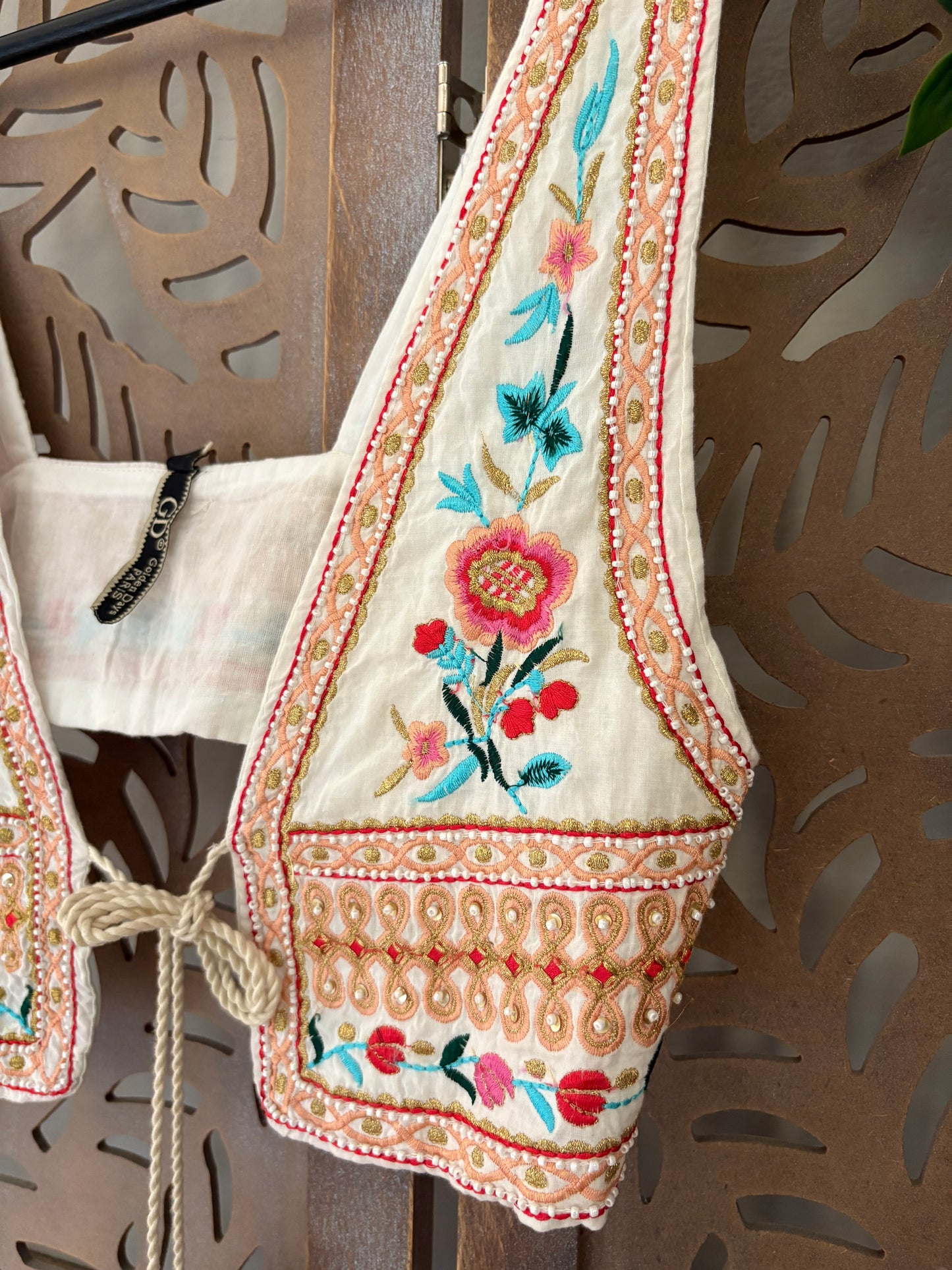 Gilet corto in cotone boho chic floreale ricamato con applicazioni di perline e chiusura con nappe