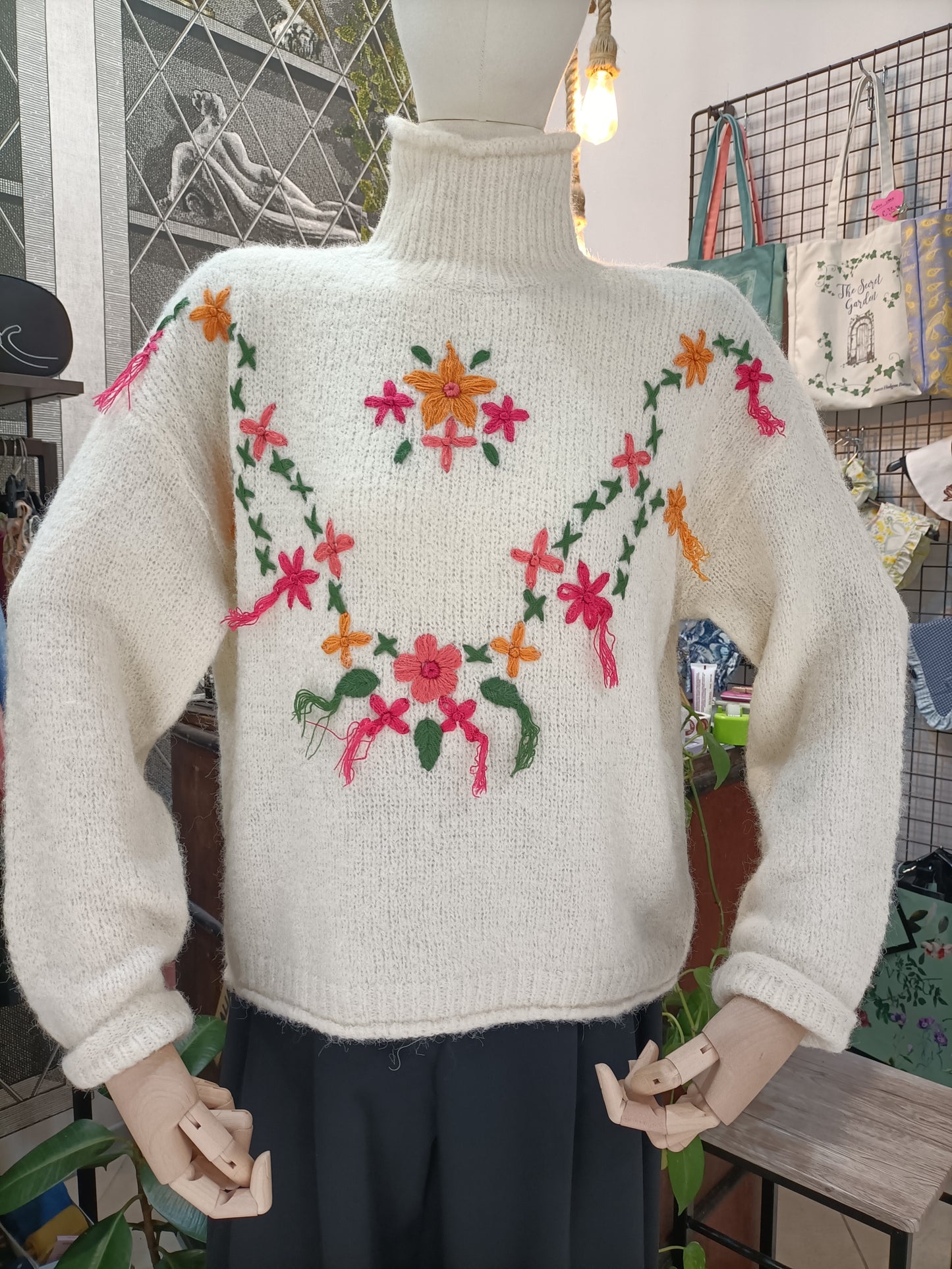 Maglione a collo alto con fiori e nappe panna