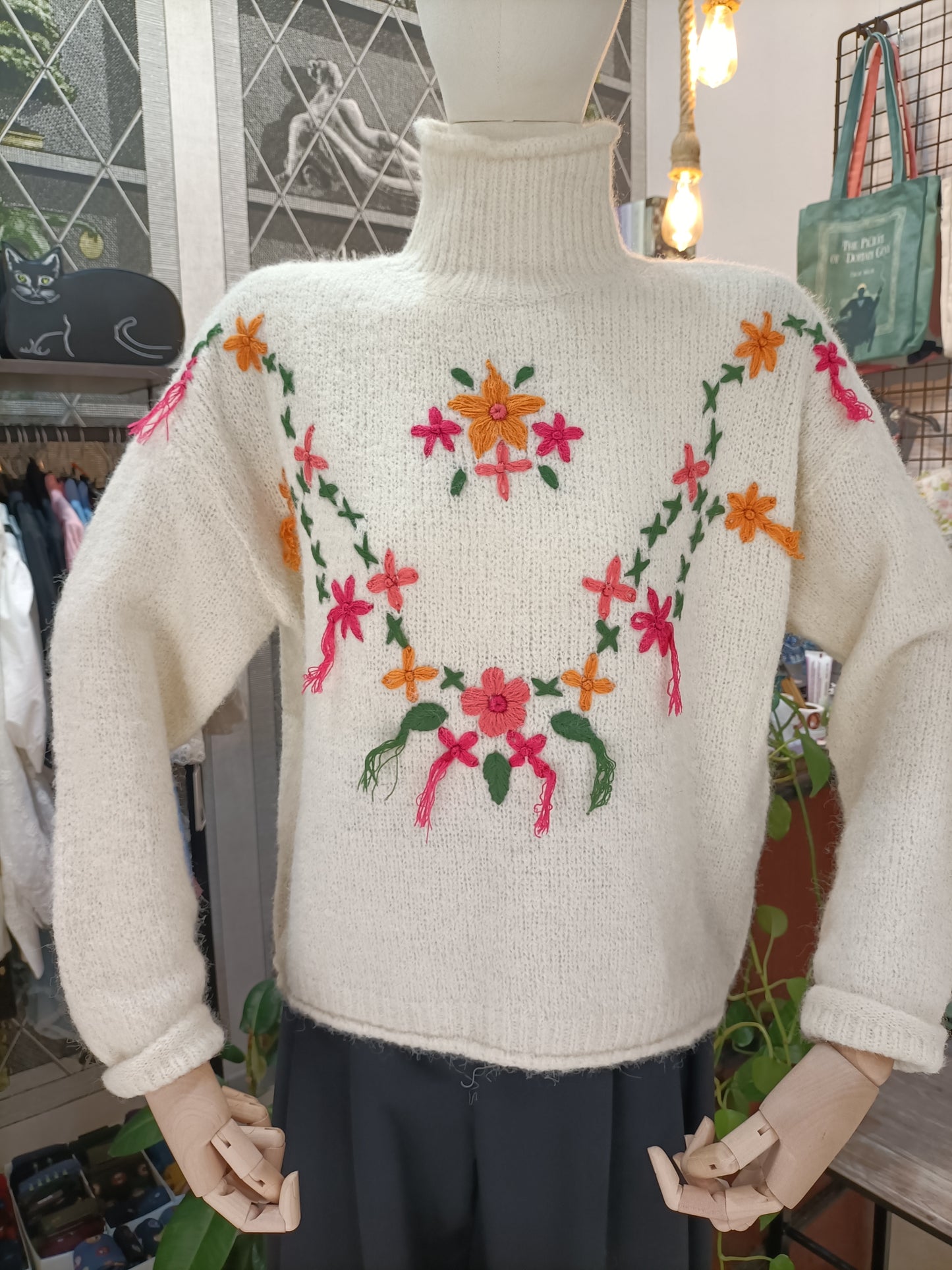 Maglione a collo alto con fiori e nappe panna